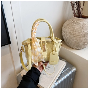 Detail of yellow PVC bucket bag with silk scarf handle and inner leather pouch