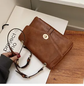 Détail du sac bandoulière vintage en cuir PU marron avec boucle rotative dorée