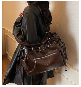 Detail of vintage brown tote bag with silver eyelets and drawstring on shoulder strap