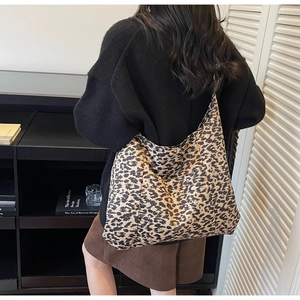 Detail of large leopard print tote bag styled with autumn sweater and corduroy skirt