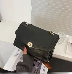 Détail du sac messager vintage noir avec fermoir doré et texture en cuir ciré à l'huile