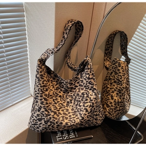 Detail view of leopard print tote bag featuring an adjustable strap and metal buckle