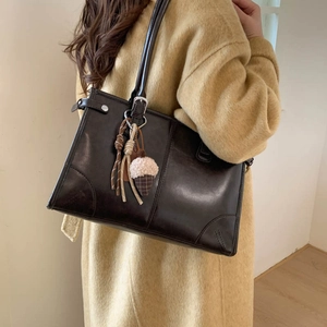 Sac cabas rétro en simili cuir marron foncé avec pompon et pendentif en fourrure