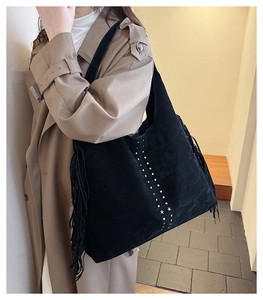 Dettaglio della borsa tote in pelle scamosciata nera con frange e borchie a stella