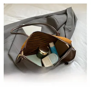 Detailed top view of the spacious inner compartment showing items in the boston bag