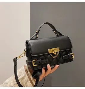 Detail der schwarzen Stepptasche mit elegantem Goldverschluss und goldenem Kettenriemen