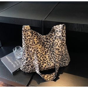 Macro detail of leopard print tote bag featuring adjustable strap and metal buckle detail