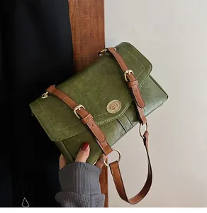 Détail du sac vintage vert olive avec lanières marron et fermoir tournant doré