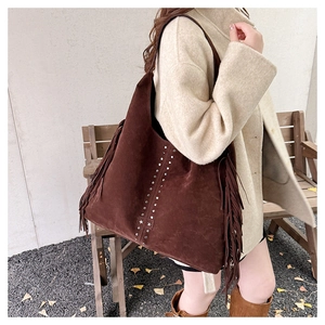 Dettaglio della borsa tote in pelle scamosciata marrone con borchie e frange decorative