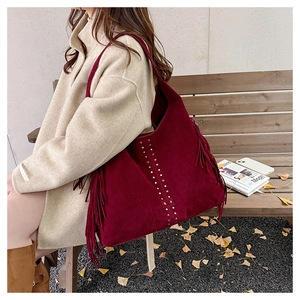 Macro di borsa tote in pelle scamosciata bordeaux con borchie metalliche e frange