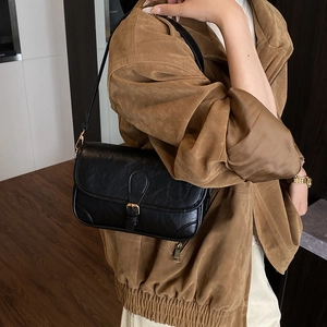 Fashionable black faux leather crossbody bag with pleated texture and gold buckle detail