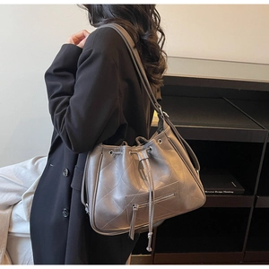 Détail du sac cabas matelassé taupe avec cordon de serrage et poche zippée métal
