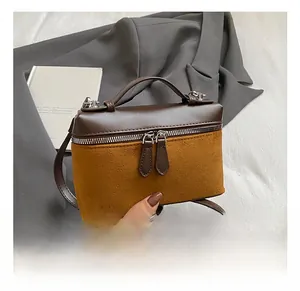 Close-up of retro color-block box bag featuring brown leather and ginger suede textures