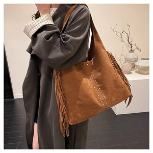 Dettaglio della borsa a tracolla vintage marrone scamosciata con frange e borchie