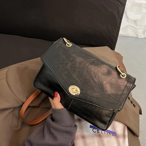 Sac bandoulière vintage noir avec fermoir doré tournant et sangle en cuir marron