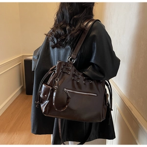 Detailed side view of a large glossy coffee brown tote bag with drawstring closure