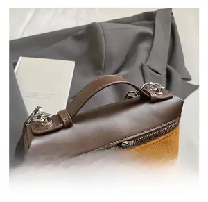Detail of vintage matte crossbody bag showing smooth brown leather handle and silver zippers