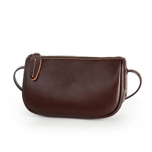 Dark brown leather crossbody bag with minimalist semi-oval design and zipper closure