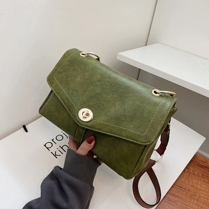Sac messager vert vintage avec fermoir anneau doré et bandoulière marron, vue de haut