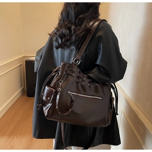 Detail of deep brown tote bag with silver zippers and drawstring in oil wax leather