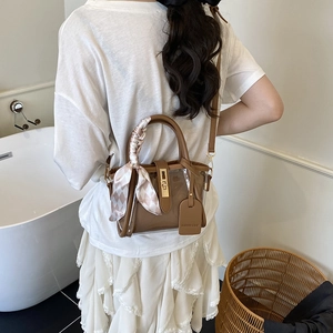 Brown and transparent patchwork bucket bag with golden twist lock and silk scarf handle