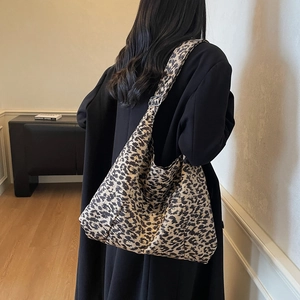 Large leopard print crossbody bag with adjustable strap shown on a black winter coat