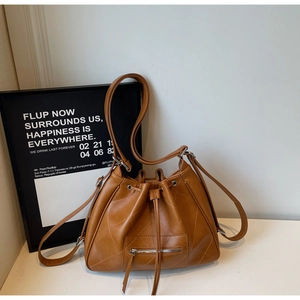 Détail du sac seau en cuir PU marron avec coutures matelassées en losange et cordon