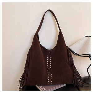 Dettaglio borsa shopper in camoscio marrone con borchie argentate, lunghe frange e stelle