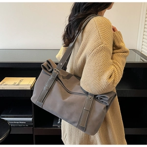 Detail of dark grey casual tote bag with adjustable metal buckle and eyelet strap