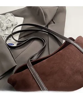 Close-up of brown suede bag with CLEAR OK embossed logo and premium leather strap