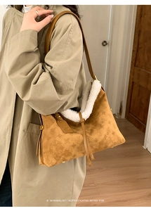 Dettaglio borsa a spalla in camoscio color cammello con motivi retrò e bordo in pelliccia
