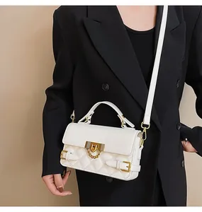 Detailansicht der gesteppten weißen Tasche mit goldenem Schloss und Kettenverzierung