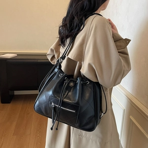Black quilted drawstring tote bag with silver zippers and large capacity for women