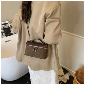 Detail of vintage crossbody bag with dual-texture splicing and smooth leather top handle