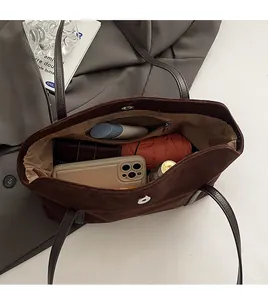 Spacious interior of brown suede tote bag showing magnetic buckle and lining