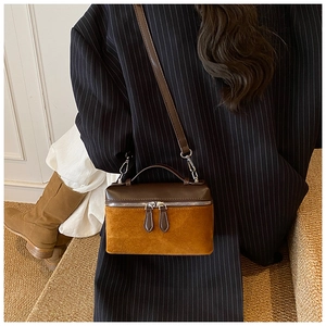 Chic retro crossbody bag in brown leather and caramel suede worn with a blazer