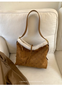 Dettaglio della borsa a secchiello in camoscio marrone con bordo in shearling e rilievi