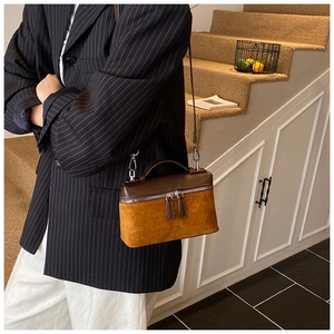 Detail of trendy crossbody square bag in suede and brown leather on model's side