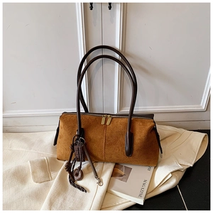 Detail of brown suede shoulder bag with vintage charm and golden double zipper closure