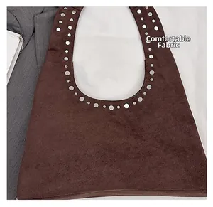 Détail du sac sous les bras en daim marron foncé avec clous argentés et tissu confortable
