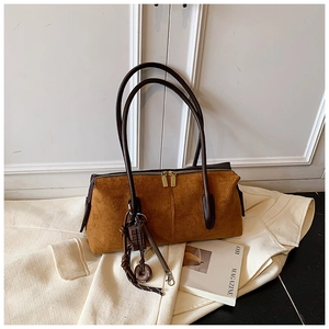 Detail view of the brown suede hobo bag with golden dual zippers and a cute charm