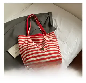 Close-up of red and white striped canvas tote bag texture on soft white bedding