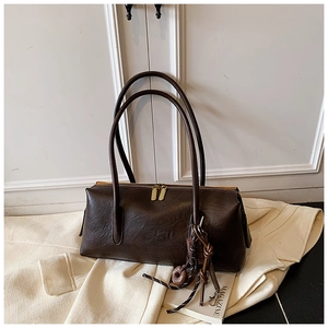 Detail of dark brown vintage faux leather shoulder bag with golden double zippers