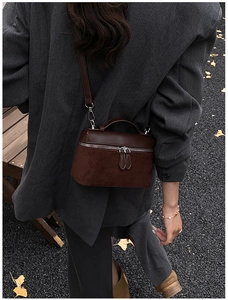 Detail of vintage dark brown handbag with dual textures and silver zippers