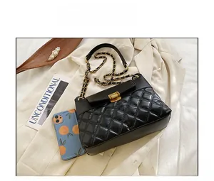 Détail du sac bandoulière matelassé noir avec chaîne dorée et fermoir rotatif