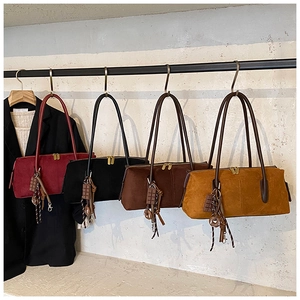 Detail view of suede shoulder bags in four colors with cute decorative charms