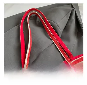 Close-up of durable red and white canvas tote bag handles with detailed stitching