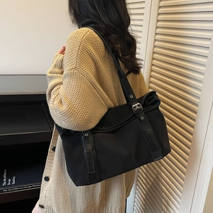Vintage large capacity black canvas tote bag with leather trim on model shoulder