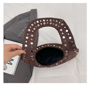 Détail d'un sac sous les aisselles en daim marron avec rivets argentés et poignée creuse