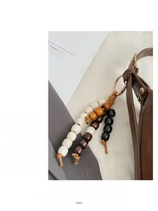 Détail d'un chic pendentif en perles de bois tressées avec fermoir doré sur un sac